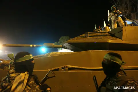 Palestinian members of the Ezzedine al-Qassam Brigades, the armed wing of the Hamas movement, gather around a mock Israeli tank on January 31, 2016 in Gaza city during a gathering to pay tribute to the brigade's militant...