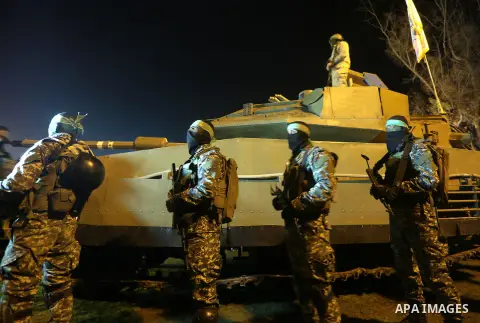 Palestinian members of the Ezzedine al-Qassam Brigades, the armed wing of the Hamas movement, gather around a mock Israeli tank on January 31, 2016 in Gaza city during a gathering to pay tribute to the brigade's militant...