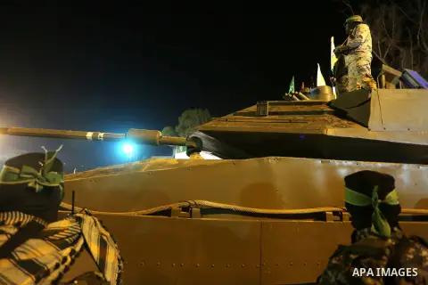 Palestinian members of the Ezzedine al-Qassam Brigades, the armed wing of the Hamas movement, gather around a mock Israeli tank on January 31, 2016 in Gaza city during a gathering to pay tribute to the brigade's militant...