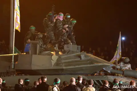Palestinian members of the Ezzedine al-Qassam Brigades, the armed wing of the Hamas movement, gather around a mock Israeli tank on January 31, 2016 in Gaza city during a gathering to pay tribute to the brigade's militant...