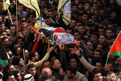 Mourners carry the body of Palestinian gunman Amjad Abu Omar, whom the Israeli army said was shot dead by soldiers after he wounded three Israelis on Sunday, during his funeral in the West Bank village of Jamain near Nab...