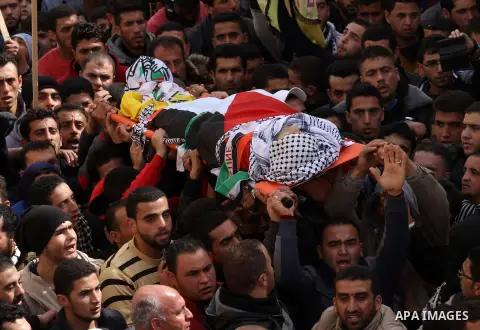 Mourners carry the body of Palestinian gunman Amjad Abu Omar, whom the Israeli army said was shot dead by soldiers after he wounded three Israelis on Sunday, during his funeral in the West Bank village of Jamain near Nab...