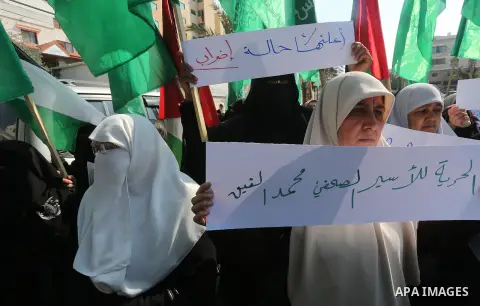 Palestinian women hold banners during a protest to show solidarity with journalist Mohammed al-Qiq who is imprisoned in an Israeli jail, Gaza city, on February 02, 2016. Photo by Mohammed Asad