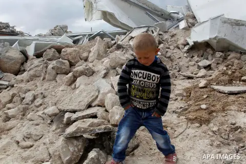 A Palestinian boy stands next on the remains of her home after it was demolished by Israeli bulldozers in a disputed military zone in the area of Musafir Jenbah, which includes several villages, south of the West Bank to...