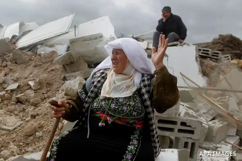 A Palestinian woman sits next on the remains of her home after it was demolished by Israeli bulldozers in a disputed military zone in the area of Musafir Jenbah, which includes several villages, south of the West Bank to...
