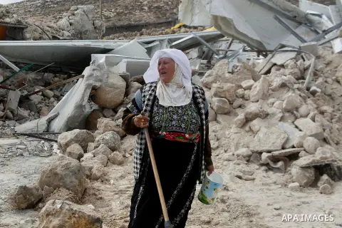 A Palestinian woman stands next on the remains of her home after it was demolished by Israeli bulldozers in a disputed military zone in the area of Musafir Jenbah, which includes several villages, south of the West Bank...