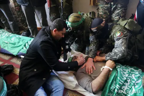 Palestinian militants mourn around the body of Ahmed al-Zahar, who was killed when a tunnel collapse on Tuesday, mourn during his funeral in the village of Al-Moghraga near central Gaza Strip, February 3, 2016. The colla...