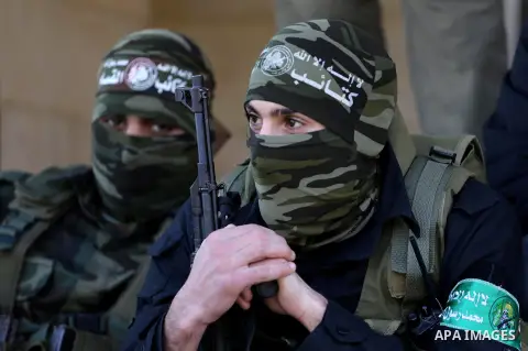 Palestinian members of the Ezzedine al-Qassam Brigades, the armed wing of the Hamas movement mourn during the funeral of fellow militant Ahmed al-Zahar in the village of Al-Moghraga near the Nuseirat refugee camp in the...