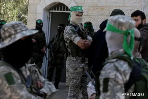Palestinian members of the Ezzedine al-Qassam Brigades, the armed wing of the Hamas movement mourn during the funeral of fellow militant Ahmed al-Zahar in the village of Al-Moghraga near the Nuseirat refugee camp in the...