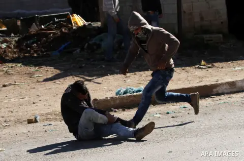 A wounded Palestinian youth lies on the ground during clashed with Israeli security forces in Qabatiya, a town near Jenin in the north of the Israeli-occupied West Bank, on February 4, 2016. Israeli forces locked down Qa...