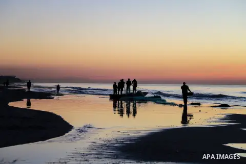 Palestinian fishermen work during the sunset on the beach of Gaza city on Feb. 04, 2016. Photo by Mohammed Dahman