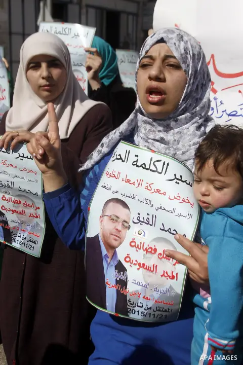 Palestinian demonstrators hold posters bearing portraits of Palestinian journalist Mohammed al-Qiq who is imprisoned in an Israeli jail during a protest in support of his hunger strike in the West Bank city of Hebron on...