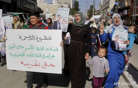 Palestinian demonstrators hold posters bearing portraits of Palestinian journalist Mohammed al-Qiq who is imprisoned in an Israeli jail during a protest in support of his hunger strike in the West Bank city of Hebron on...