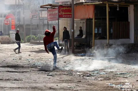 A Palestinian protester kicks back a tear gas canister fired by Israeli security forces during clashes in the Palestinian town of Qabatiya, near Jenin in the north of the Israeli-occupied West Bank, on February 5, 2016....
