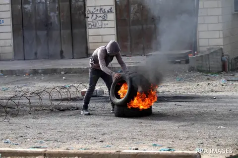 A Palestinian protester burns tires during clashes with Israeli security forces in the Palestinian town of Qabatiya, near Jenin in the north of the Israeli-occupied West Bank, on February 5, 2016. The Israeli army blocke...