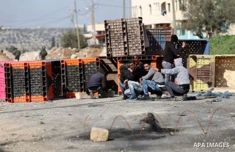 A Palestinian protester throws stones towards Israeli security forces during clashes in the Palestinian town of Qabatiya, near Jenin in the north of the Israeli-occupied West Bank, on February 5, 2016. The Israeli army b...