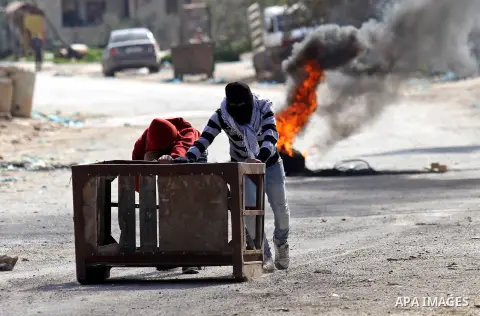 Palestinian protesters push a container during clashes with Israeli security forces in the Palestinian town of Qabatiya, near Jenin in the north of the Israeli-occupied West Bank, on February 5, 2016. The Israeli army bl...