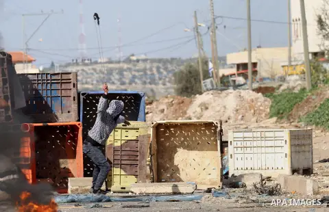 A Palestinian protester throws stones towards Israeli security forces during clashes in the Palestinian town of Qabatiya, near Jenin in the north of the Israeli-occupied West Bank, on February 5, 2016. The Israeli army b...