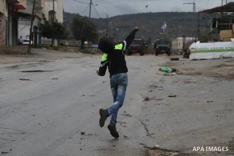 A Palestinian protester prepares his sling to hurl stones towards Israeli troops during clashes in the West Bank town of Qabatya, near Jenin February 6, 2016. On Wednesday, three young Palestinian men from Qabatya wieldi...