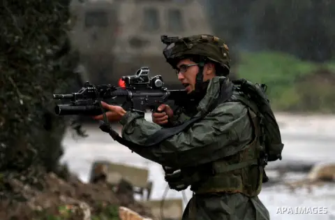 A member of the Israeli security forces aims fire during clashes with Palestinian protestors in the village of Qabatiya, near the West Bank town of Jenin, during clashes on February 6, 2016. Three Palestinians from Qabat...
