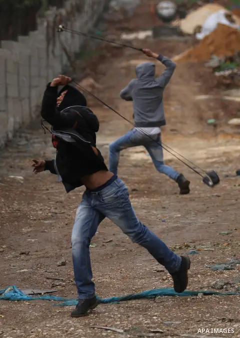 A Palestinian protester prepares his sling to hurl stones towards Israeli troops during clashes in the West Bank town of Qabatya, near Jenin February 6, 2016. On Wednesday, three young Palestinian men from Qabatya wieldi...
