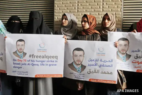 Palestinian journalists hold posters bearing portraits of Palestinian journalist Mohammed al-Qiq who is imprisoned in an Israeli jail during a protest in support of his hunger strike in Rafah in the southern Gaza strip o...