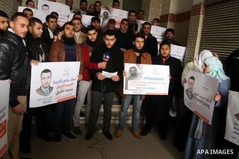 Palestinian journalists hold posters bearing portraits of Palestinian journalist Mohammed al-Qiq who is imprisoned in an Israeli jail during a protest in support of his hunger strike in Rafah in the southern Gaza strip o...