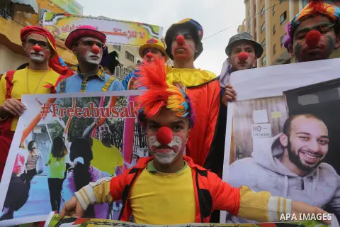 Palestinians dressed as clowns take part in a protest demanding release the prisoners in Israeli jails, in front of Red cross office, in Gaza city, on February 8, 2016. Photo by Mohammed Asad