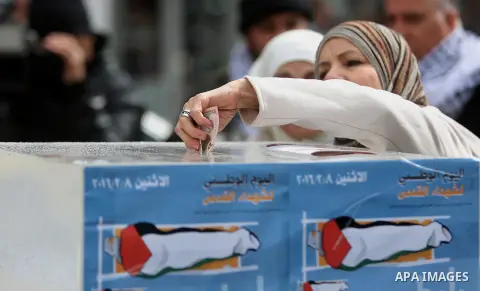A Palestinian woman donates money during a fundraising campaign aimed at rebuilding the families houses of Jerusalem Martyrs, after demolished by Israeli authorities in the West Bank city of Ramallah, on February 8, 2016...