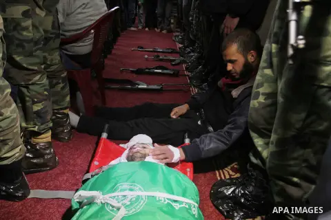 Palestinian members of the Ezzedine al-Qassam Brigades, the armed wing of the Hamas movement pray over the body of their comrade Marwan Maarouf, 27, during his funeral in Khan Yunis in the southern Gaza Strip, on Februar...