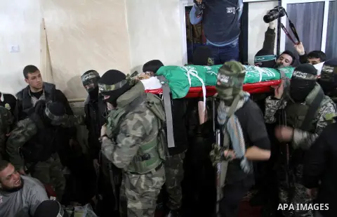 Palestinian members of the Ezzedine al-Qassam Brigades, the armed wing of the Hamas movement carry the body of their comrade Marwan Maarouf, 27, during his funeral in Khan Yunis in the southern Gaza Strip, on February 9,...