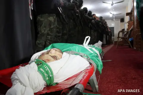 Palestinian members of the Ezzedine al-Qassam Brigades, the armed wing of the Hamas movement pray over the body of their comrade Marwan Maarouf, 27, during his funeral in Khan Yunis in the southern Gaza Strip, on Februar...