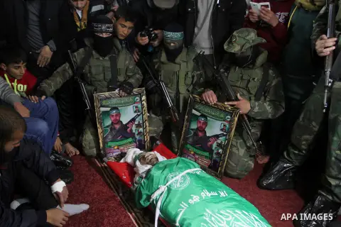 Palestinian members of the Ezzedine al-Qassam Brigades, the armed wing of the Hamas movement pray over the body of their comrade Marwan Maarouf, 27, during his funeral in Khan Yunis in the southern Gaza Strip, on Februar...