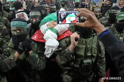 Palestinian members of the Ezzedine al-Qassam Brigades, the armed wing of the Hamas movement carry the body of their comrade Marwan Maarouf, 27, during his funeral in Khan Yunis in the southern Gaza Strip, on February 9,...