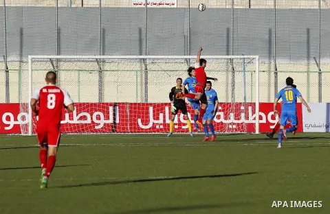 Ahly Al-Khalil football club's players (in red) and FC Khujand club's players compete during the football match crucial AFC Champions League Playoff phase at Dura Stadium in the West Bank city of Hebron on Feb. 09, 2016....