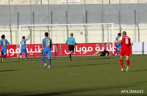 Ahly Al-Khalil football club's players (in red) and FC Khujand club's players compete during the football match crucial AFC Champions League Playoff phase at Dura Stadium in the West Bank city of Hebron on Feb. 09, 2016....