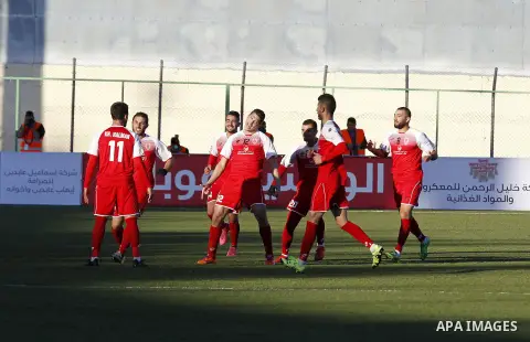 Ahly Al-Khalil football club's players (in red) and FC Khujand club's players compete during the football match crucial AFC Champions League Playoff phase at Dura Stadium in the West Bank city of Hebron on Feb. 09, 2016....