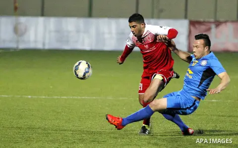 Ahly Al-Khalil football club's players (in red) and FC Khujand club's players compete during the football match crucial AFC Champions League Playoff phase at Dura Stadium in the West Bank city of Hebron on Feb. 09, 2016....