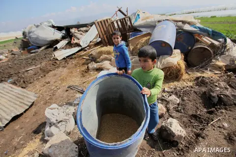 Palestinians collect belongings near the rubble of their house that were demolished by the Israeli army, in the Jordan valley, near the West Bank town of Tubas on February 11, 2016. Israel is planning to annex the Jordan...