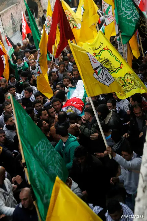 Palestinian mourners carry the body of Omar Jawabra, who was killed by Israeli fire during clashes near Hebron the day before, during his funeral at al-Aroub Palestinian refugee camp, north the West Bank city of Hebron o...