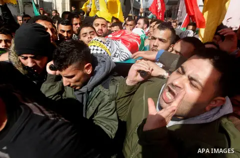 Palestinian mourners carry the body of Omar Jawabra, who was killed by Israeli fire during clashes near Hebron the day before, during his funeral at al-Aroub Palestinian refugee camp, north the West Bank city of Hebron o...