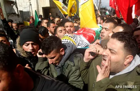 Palestinian mourners carry the body of Omar Jawabra, who was killed by Israeli fire during clashes near Hebron the day before, during his funeral at al-Aroub Palestinian refugee camp, north the West Bank city of Hebron o...