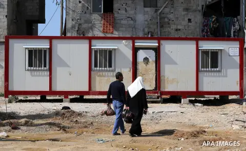 Palestinians walk past a house wihch destroyed during 2014 war, in Shijaiyah neighborhood in the east of Gaza city on Feb. 11, 2016. Rebuilding of Palestinian houses which destroyed during 2014 war and funded by Kuwaiti...