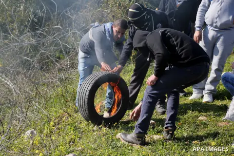 Palestinian protesters burn tires during clashes with Israeli security forces following a demonstration in solidarity with Palestinian prisoners in Israeli jails, outside the compound of the Israeli Ofer Military Prison,...