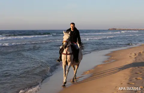 A Palestinian youth shows his skills on rides horses on the beach of Gaza city on Feb. 12, 2016. Photo by Mohammed Asad