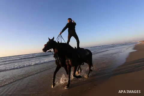 A Palestinian youth shows his skills on rides horses on the beach of Gaza city on Feb. 12, 2016. Photo by Mohammed Asad