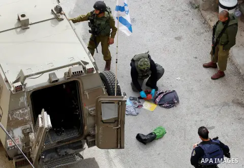 Israeli security forces carry the body of a Palestinian woman tried to stab an Israeli soldier before being shot dead, in the Israeli occupied West Bank city of Hebron, on February 13, 2016. An Israeli army statement sai...