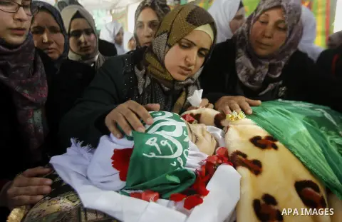 The relatives of Palestinian Kalzar al-Uweiwi, a Palestinian teenager who was killed a day earlier following a reported stabbing attack, mourn over her body ahead of her funeral, in the Israeli occupied West Bank city of...