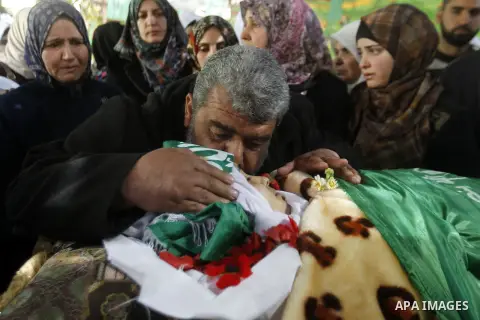 The relatives of Palestinian Kalzar al-Uweiwi, a Palestinian teenager who was killed a day earlier following a reported stabbing attack, mourn over her body ahead of her funeral, in the Israeli occupied West Bank city of...