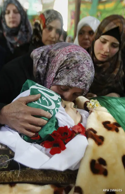 The relatives of Palestinian Kalzar al-Uweiwi, a Palestinian teenager who was killed a day earlier following a reported stabbing attack, mourn over her body ahead of her funeral, in the Israeli occupied West Bank city of...